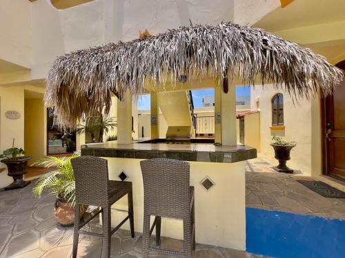 a small bar with two chairs under a straw roof at Puerto Nuevo Surf Villa Margarita 2BR with pool in Raulis