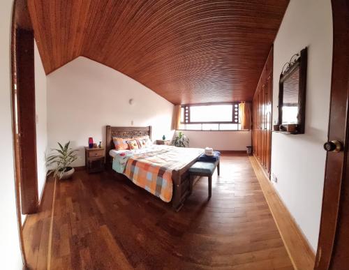a bedroom with a bed and a wooden ceiling at Hostal Casalé Usaquén Embajada de Mexico in Bogotá