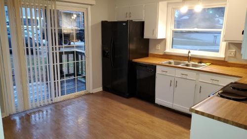 a kitchen with a black refrigerator and a sink at Sparkling Fresh Soldier's Pad 7 Mi to Fort Bragg in Fayetteville