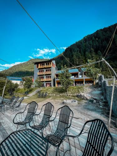 a group of chairs sitting in front of a building at Bela Resorts Naran in Nārān