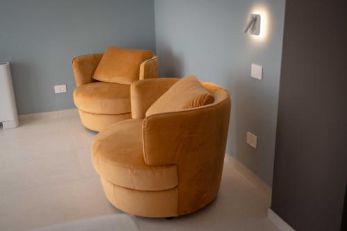 two chairs and a chair in a room at Palmar Boutique Hotel in Campofelice di Roccella