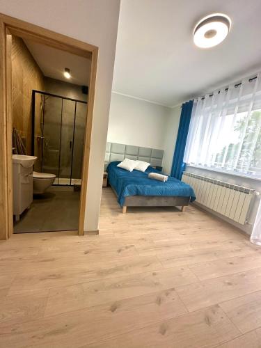 a bedroom with a bed and a bathroom with a tub at Willa Dominik 2 in Jastarnia