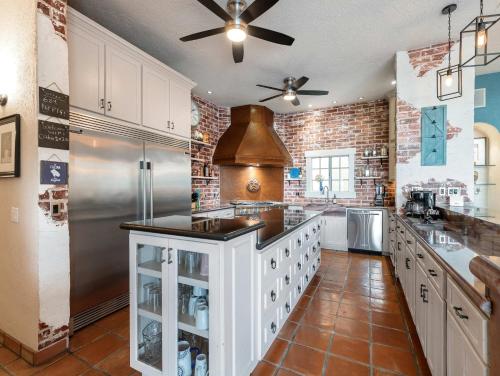 a large kitchen with a refrigerator and a stove at Elegant Hacienda Villa for 20, Ocean Views, Pool in San José del Cabo
