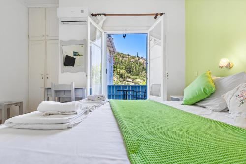 a bedroom with a large white bed with a green rug at Hotel Selini in Agios Nikitas