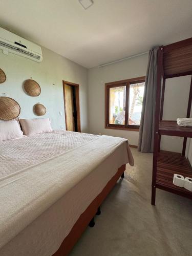 a bedroom with a large bed and a window at Casita Beach House in Itarema