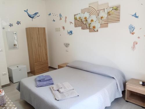 a bedroom with a bed with towels and birds on the wall at Gigi&Mary in Alghero