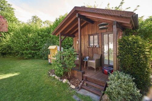 a wooden cabin with a table and a chair in a yard at Ferienhaus am Spiegelberg in Lemgo in Lemgo