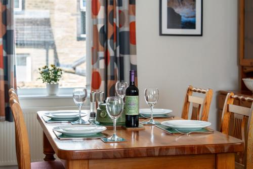 a table with a bottle of wine and glasses at AIRE VUE - Skipton in Skipton