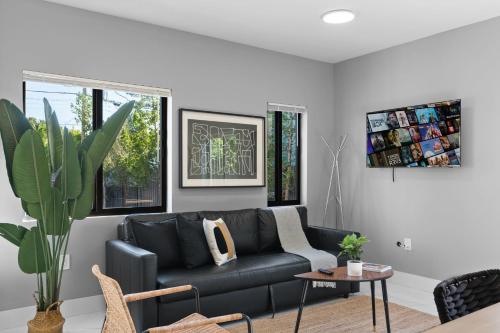 a living room with a black couch and a table at Amazing Townhouse w Free Parking in Miami
