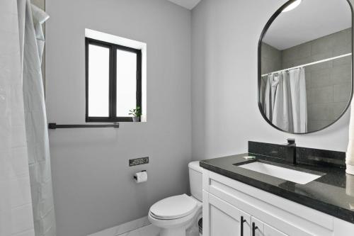 Un baño blanco con lavabo y espejo. en Amazing Townhouse w Free Parking, en Miami