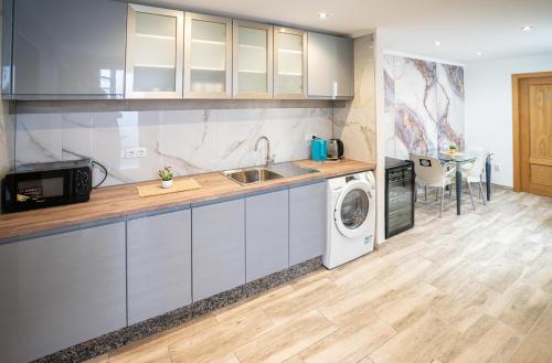 une cuisine avec un évier et une machine à laver dans l'établissement Casa Brava, à Alicante