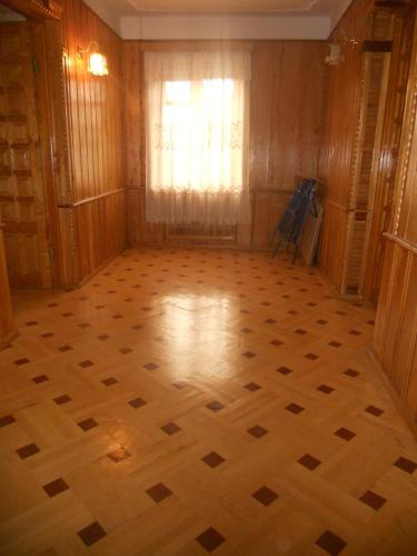 an empty room with a wooden floor and a window at Guli in Gori