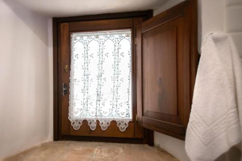 a door with a window with a curtain on it at La casetta affittacamere in Bevagna