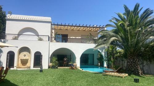 a house with a swimming pool and a palm tree at Dream villa in Korba in Korba