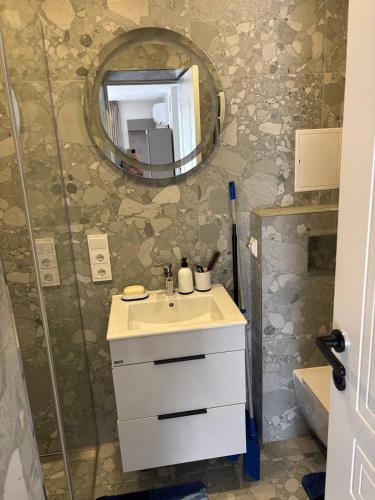 a bathroom with a sink and a mirror at Studio Flat by the sea in Melnragė