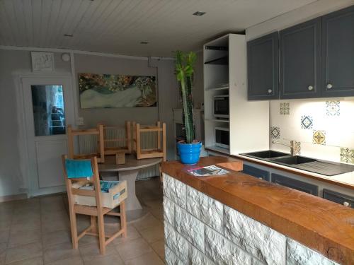 a kitchen with a counter and a table and chairs at Gîte de la Croix du Bonhomme à Champeix in Champeix