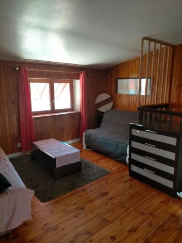 - un salon avec un lit et une table basse dans l'établissement Gîte de la Croix du Bonhomme à Champeix, à Champeix