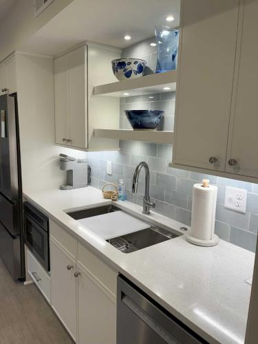 a white kitchen with a sink and a refrigerator at 1515 Deer Pointe Villa in Seabrook Island