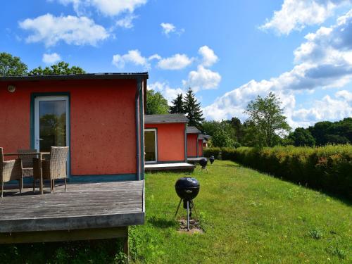 a house with a grill on the side of a yard at Ferienhaus am Garder See Inselblick in Lohmen