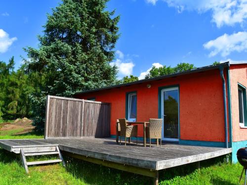 a tiny house with a table and chairs on a deck at Ferienhaus am Garder See Inselblick in Lohmen