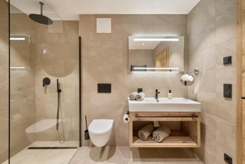 a bathroom with a sink and a toilet and a shower at Das Refugium Mountain Apartment Ötztal - Längenfeld in Längenfeld
