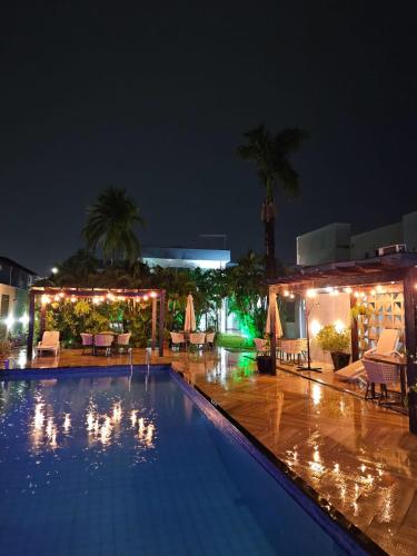 a swimming pool at night with chairs and umbrellas at Blue Inn Hotel in Boa Vista