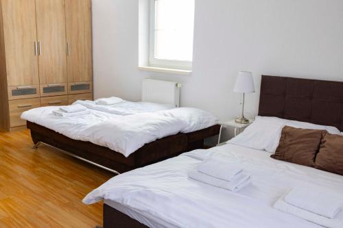a room with two beds and a window at Penzión Alpský dom in Vitanová
