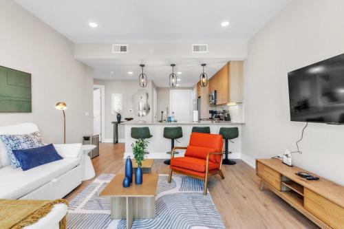 a living room with a white couch and a red chair at Lux 2BD with KINGS - Pier Views - Near Fishtown! in Philadelphia