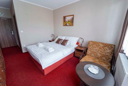 a small hotel room with a bed and a chair at Penzión Alpský dom in Vitanová