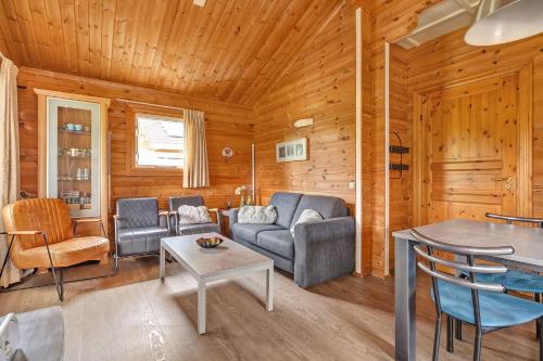 a living room with a couch and a table at Fins Chalet op vakantiepark in Gramsbergen