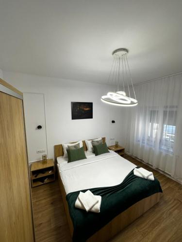 a bedroom with a large bed and a chandelier at Moin Apartment in Sibiu