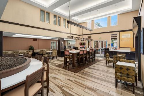 a rendering of a cafeteria with tables and chairs at Hampton Inn & Suites Seattle North/Lynnwood in Lynnwood