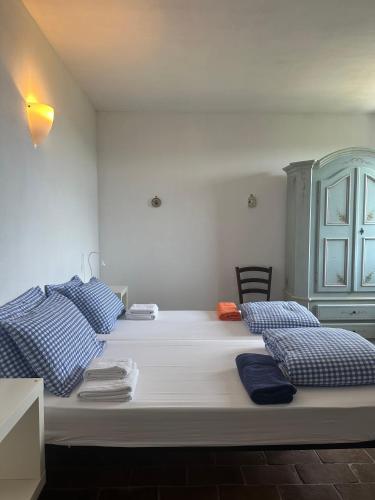 a bedroom with two beds with blue and white pillows at Collina Di Sopra in Tresana