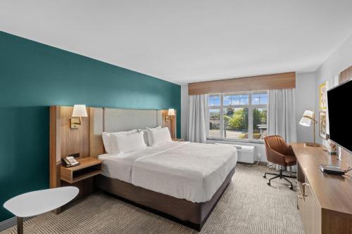 a hotel room with a bed and a desk and a television at Holiday Inn Hotel & Suites Surrey East - Cloverdale by IHG in Surrey