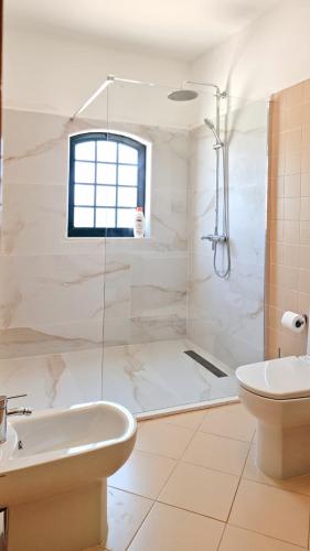 a bathroom with a shower and a toilet and a sink at Casa Santos in Albufeira