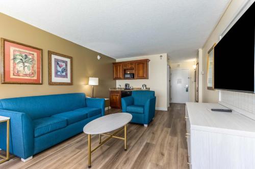 a living room with a blue couch and a table at Holiday Inn & Suites Clearwater Beach by IHG in Clearwater Beach
