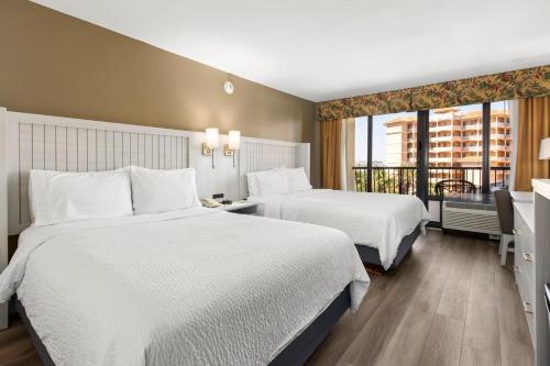 a hotel room with two beds and a balcony at Holiday Inn & Suites Clearwater Beach by IHG in Clearwater Beach