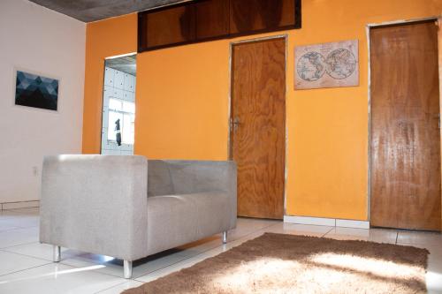 里约热内卢Hostel Vidigal TPrysthon的带沙发和橙色墙壁的客厅
