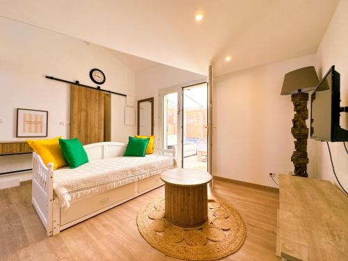 - une chambre dotée d'un lit avec des oreillers verts et jaunes dans l'établissement Le Flamant Rose, à Vic-la-Gardiole