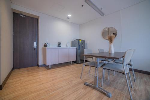 a room with a table and chairs and a refrigerator at SHG Liv Zona G Hotel in Bogotá
