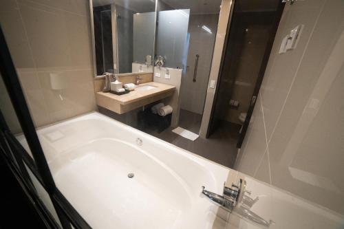 a bathroom with a large tub and a sink at SHG Liv Zona G Hotel in Bogotá