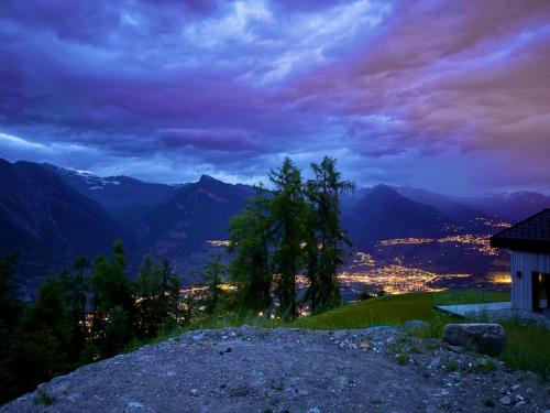 a view of a city from a mountain at night at Authentique chalet familial in Nendaz