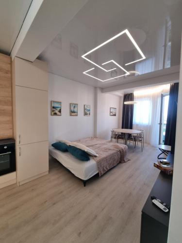 a large bedroom with a bed and a table at Sunrise Breeze Apartment in Constanţa