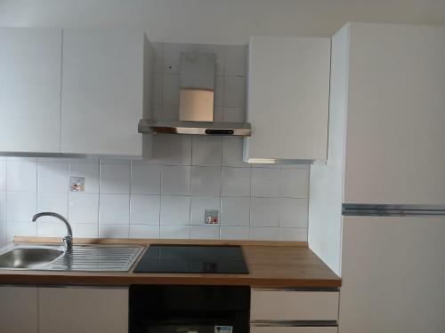 a kitchen with white cabinets and a sink at Casa Dolce Paola in Cagliari