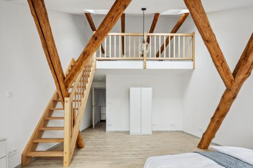 a loft conversion with a wooden staircase and white walls at Spacious two-storey apartment with a terrace in the city center in Benešov