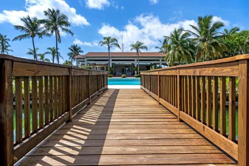 a wooden bridge leading to a pool with a house at Villa Gem Tropical Charm Prime Location in Sabana