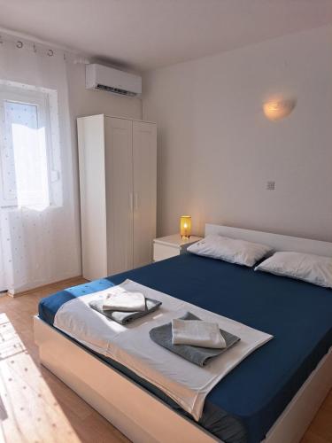 a bedroom with a large bed with a blue blanket at Apartman Matea in Igrane