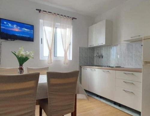 a kitchen with a table and chairs in a kitchen at Apartman Matea in Igrane