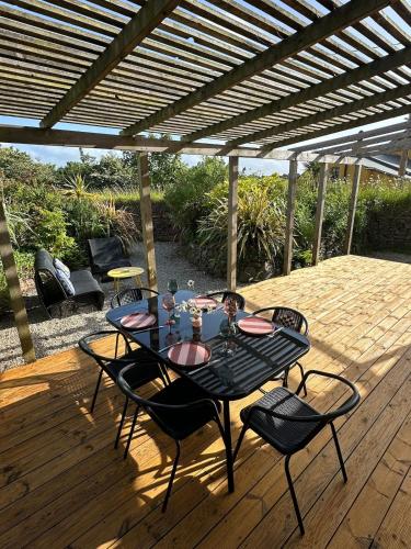 a patio with a table and chairs on a wooden deck at Static Caravan Near Perranporth in Perranporth