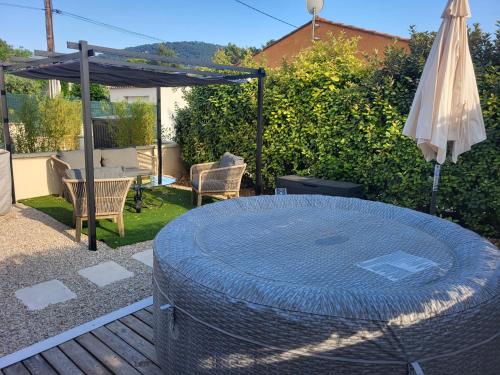un patio avec une table et un parasol dans l'établissement Mas du Magaou Pres de Marseille, Cassis, Aix-en-Provence, à Auriol